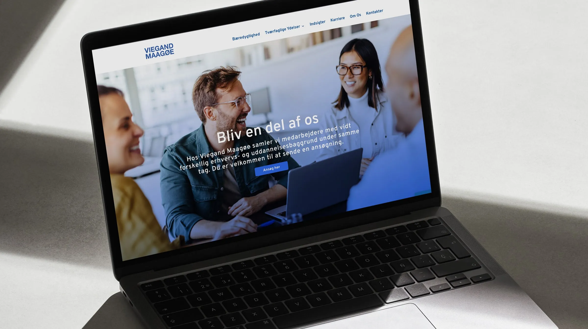 Laptop med et websitekoncept for Viegand Maagøe, der viser karrieresiden: Bliv en del af os.